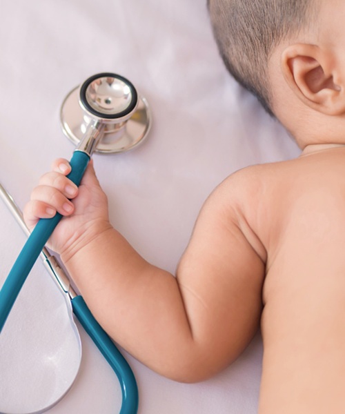 medical instruments stethoscope in hand of newborn baby girl